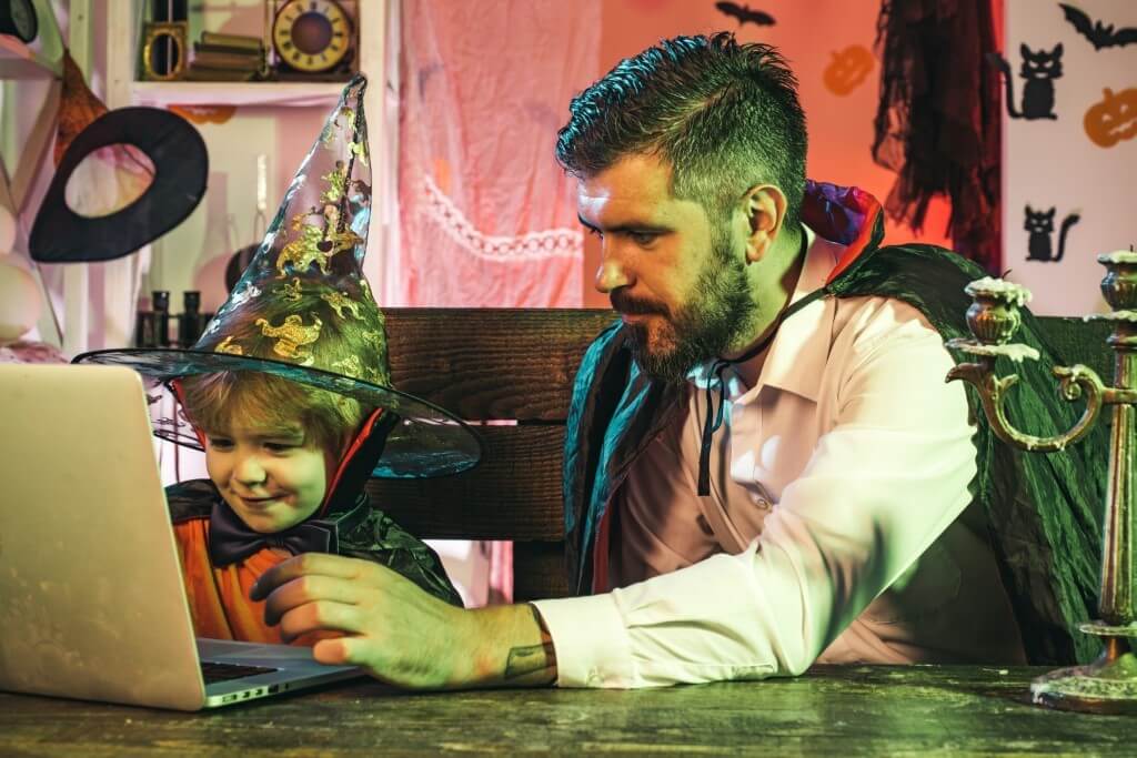 father and child dressed up on the computer