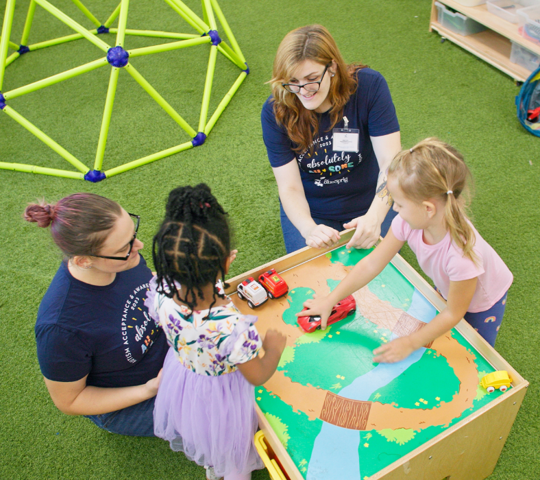 Two adults and two kids sitting around a table playing