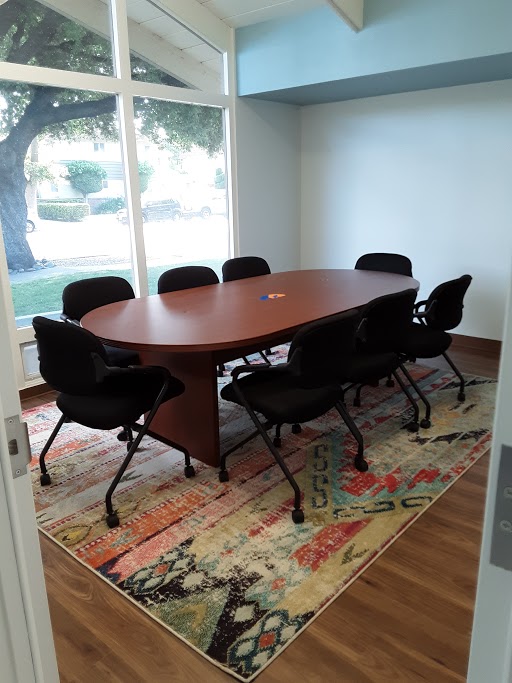 A conference room with a table and chairs at a BlueSprig autism center.