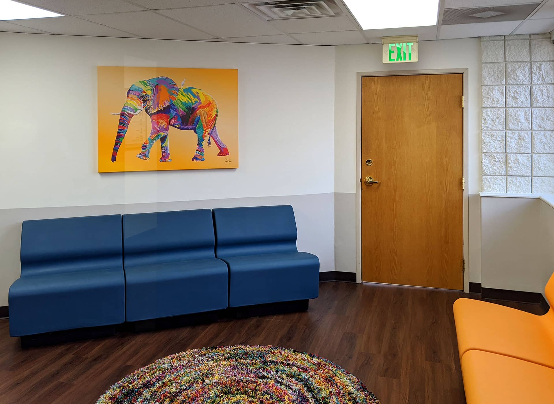 The waiting room at BlueSprig autism centers features fun art and comfortable blue couches.