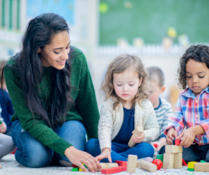 A BCBA plays with two early intervention clients