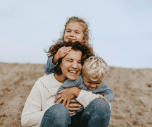 A mother hugs two young children