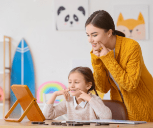A therapist and child both point towards their mouths