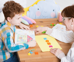A therapist talks to a child while coloring