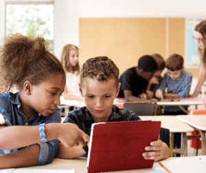 Two children look at a tablet together