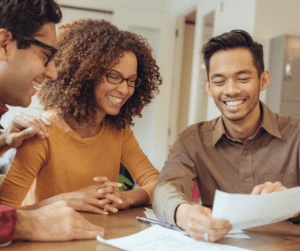 Three adults look at a paper.