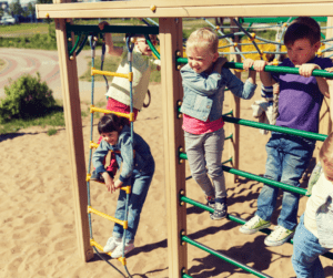 Children play on monkey bars at a park