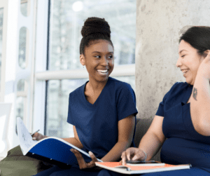 Two BCBAs study together and laugh.