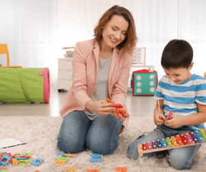 BCBA plays a toy xylophone with a young boy.